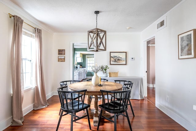 dining room featuring dark wood-style floors, plenty of natural light, baseboards, crown molding, and a textured ceiling