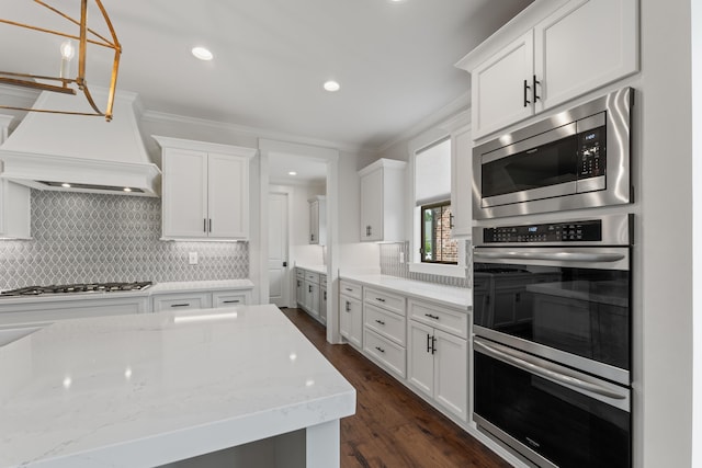 940 Cypress Vine Cv, Collierville, TN 38017 - kitchen with appliances with stainless steel finishes, tasteful backsplash, white cabinetry, crown molding, and light stone counters