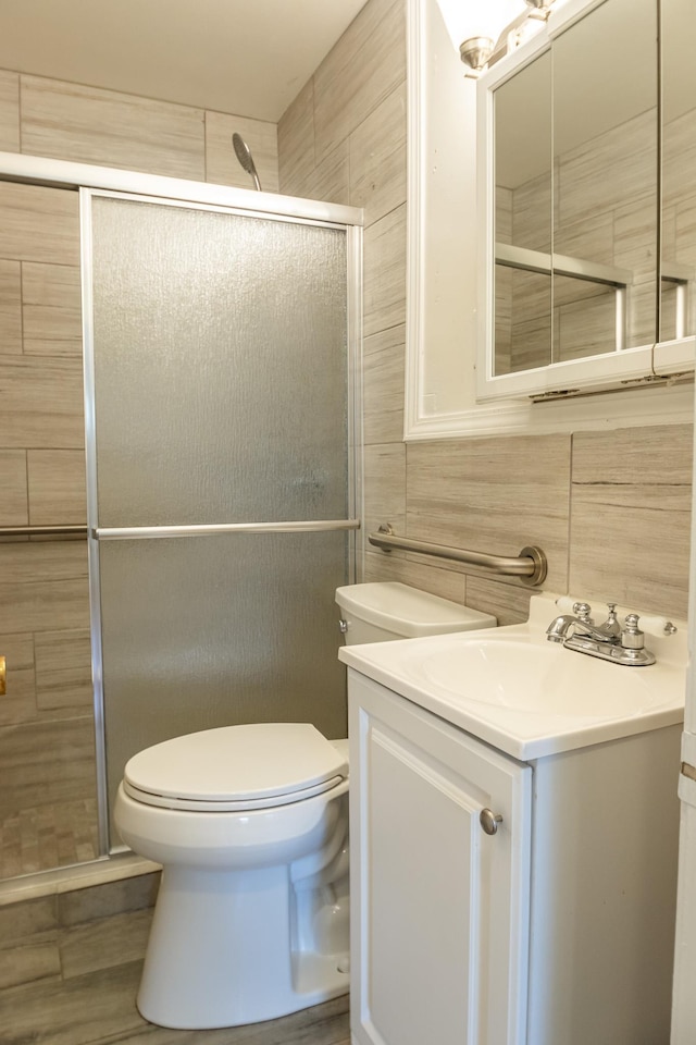 4486 Mayo Ave, Memphis, TN 38128 - bathroom featuring a shower stall, toilet, vanity, and tile walls