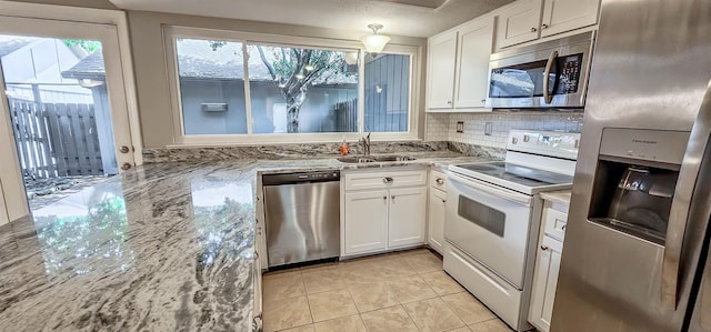 1731 Hobbits Glen Dr Unit 14, Germantown, TN 38138 - kitchen featuring appliances with stainless steel finishes, a sink, white cabinets, and light stone counters