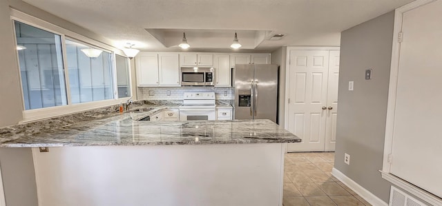 1731 Hobbits Glen Dr Unit 14, Germantown, TN 38138 - kitchen with stainless steel appliances, a peninsula, a sink, light stone countertops, and white cabinets