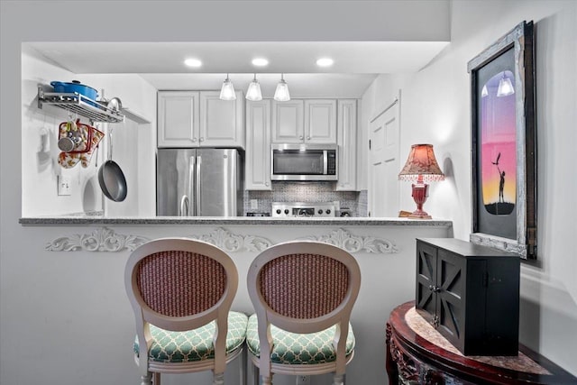 2268 Tunis Cv Unit 2268, Memphis, TN 38104 - kitchen with appliances with stainless steel finishes, decorative backsplash, white cabinets, recessed lighting, and a kitchen breakfast bar