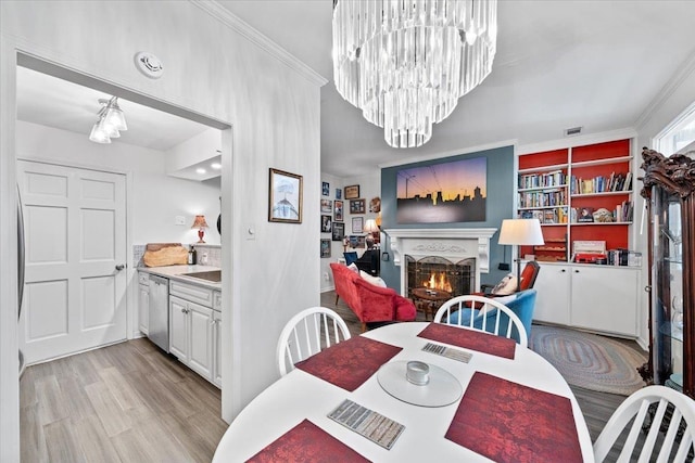 2268 Tunis Cv Unit 2268, Memphis, TN 38104 - dining space featuring a lit fireplace, light wood finished floors, ornamental molding, a chandelier, and built in features