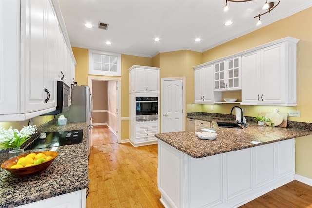 7475 Willey Rd, Germantown, TN 38138 - kitchen featuring appliances with stainless steel finishes, a sink, a peninsula, light wood finished floors, and white cabinetry