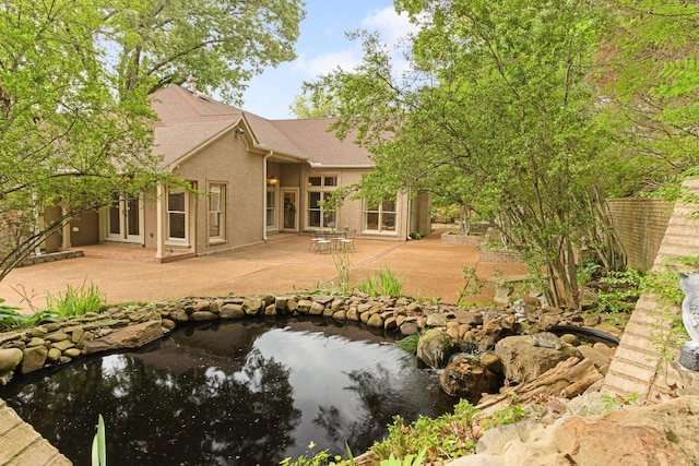7475 Willey Rd, Germantown, TN 38138 - back of house featuring brick siding, a garden pond, a patio area, and a shingled roof