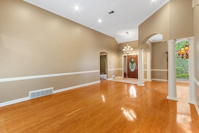 7475 Willey Rd, Germantown, TN 38138 - unfurnished living room with arched walkways, a chandelier, decorative columns, baseboards, and high vaulted ceiling
