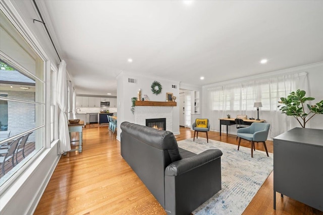 4539 Kings Park Rd, Memphis, TN 38117 - living area with crown molding, a fireplace, light wood finished floors, and recessed lighting