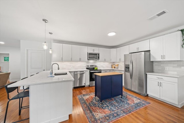 4539 Kings Park Rd, Memphis, TN 38117 - kitchen with appliances with stainless steel finishes, a peninsula, a sink, decorative backsplash, and white cabinetry