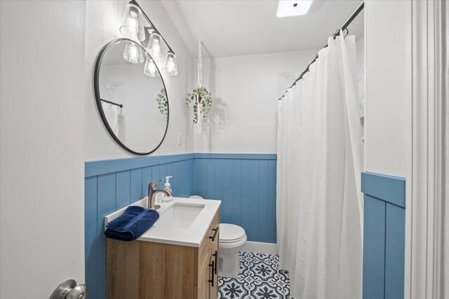 4539 Kings Park Rd, Memphis, TN 38117 - bathroom featuring wainscoting, toilet, vanity, and curtained shower