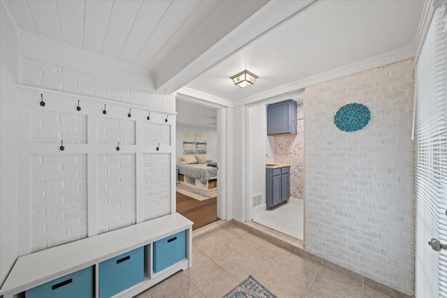 4539 Kings Park Rd, Memphis, TN 38117 - mudroom with crown molding, light tile patterned floors, and brick wall