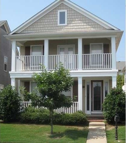 view of front of house featuring a balcony, covered porch, and a front lawn