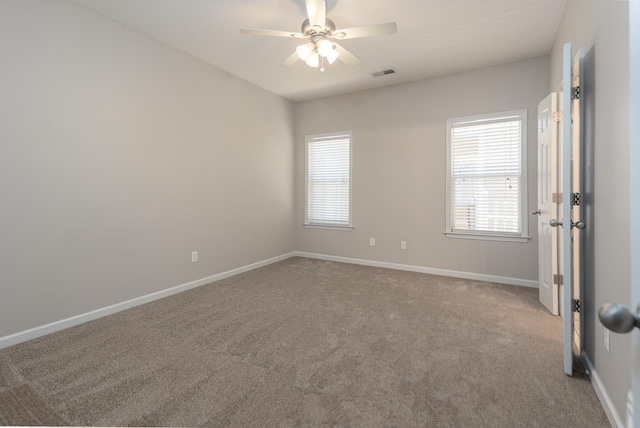 unfurnished room with healthy amount of natural light, carpet floors, ceiling fan, and baseboards