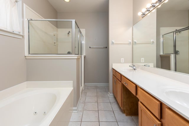bathroom featuring a stall shower, a tub with jets, double vanity, tile patterned flooring, and baseboards