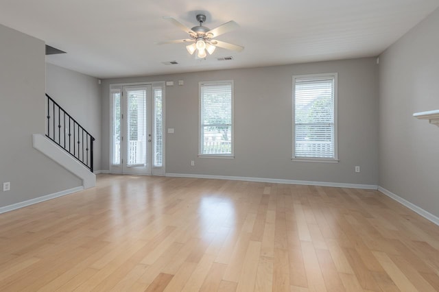 foyer entrance with a ceiling fan, light wood-style floors, stairway, and baseboards
