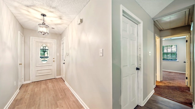 979 Ray Bluff Rd, Millington, TN 38053 - hallway featuring attic access, light wood-style flooring, baseboards, a textured ceiling, and a chandelier