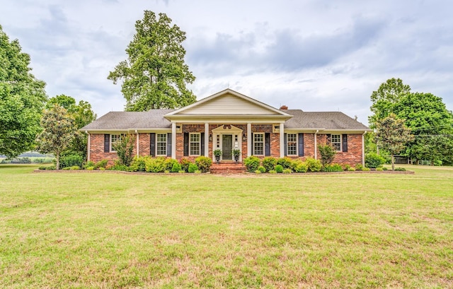 view of front of house featuring a front lawn, brick siding, and covered porch