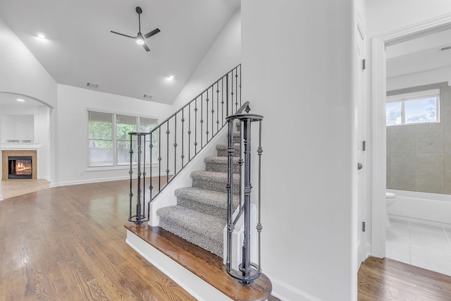 1235 Gimel Ln, Cordova, TN 38016 - stairway featuring ceiling fan, a tile fireplace, arched walkways, baseboards, and wood finished floors