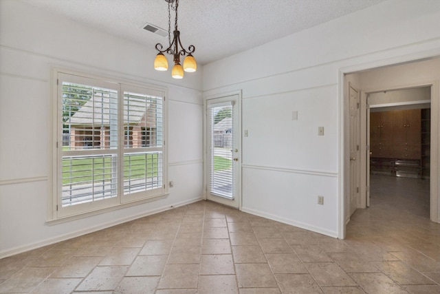 3187 Valley Lake Dr, Bartlett, TN 38135 - unfurnished dining area featuring a chandelier, a textured ceiling, baseboards, and light stone finish floors