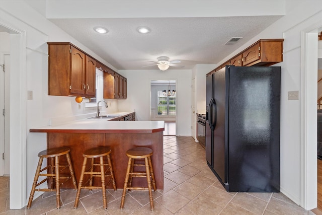 3187 Valley Lake Dr, Bartlett, TN 38135 - kitchen with black refrigerator with ice dispenser, a sink, a peninsula, brown cabinets, and light countertops