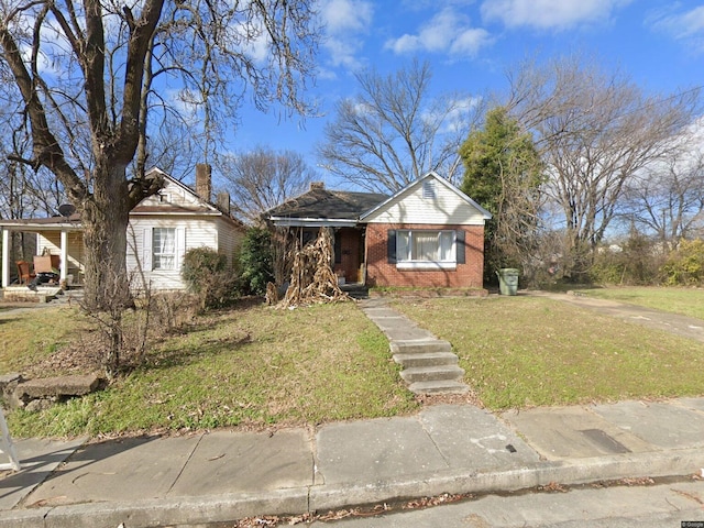 1057 Walk Pl, Memphis, TN 38106 - view of front facade with brick siding, a front yard, and a chimney
