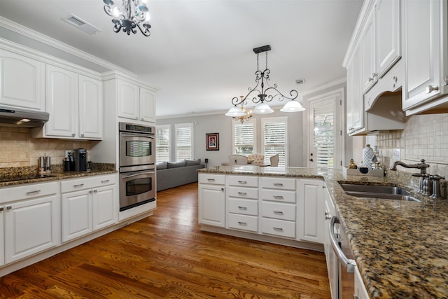215 Ivy Grove Ln, Collierville, TN 38017 - kitchen featuring a chandelier, a sink, appliances with stainless steel finishes, a peninsula, and crown molding