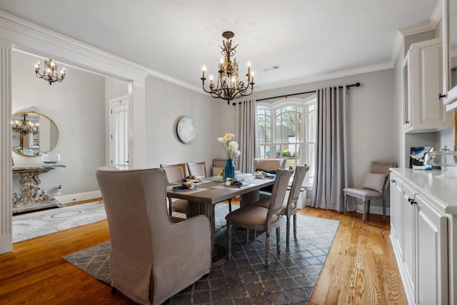 215 Ivy Grove Ln, Collierville, TN 38017 - dining area featuring a chandelier, wood finished floors, crown molding, and baseboards