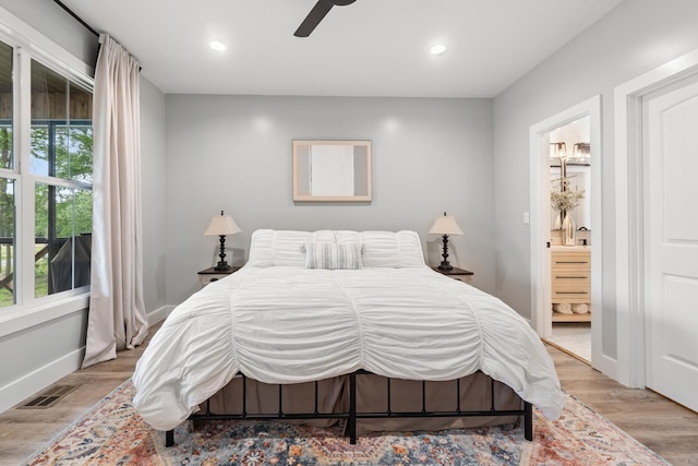 bedroom with wood finished floors, recessed lighting, ensuite bath, baseboards, and ceiling fan