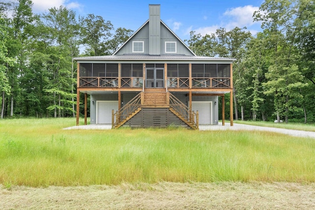 view of front of property featuring a sunroom, an attached garage, and stairway