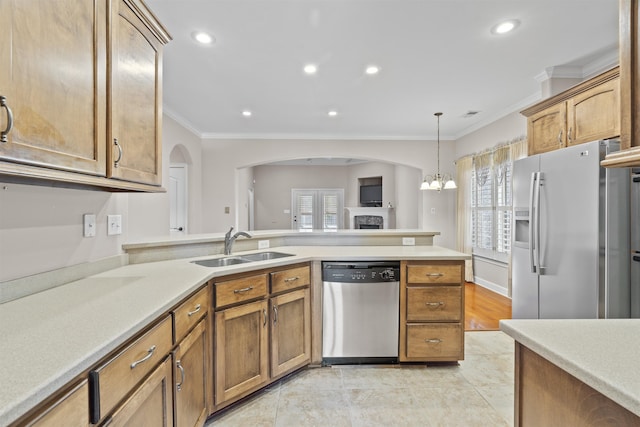 kitchen featuring appliances with stainless steel finishes, ornamental molding, a sink, plenty of natural light, and light countertops