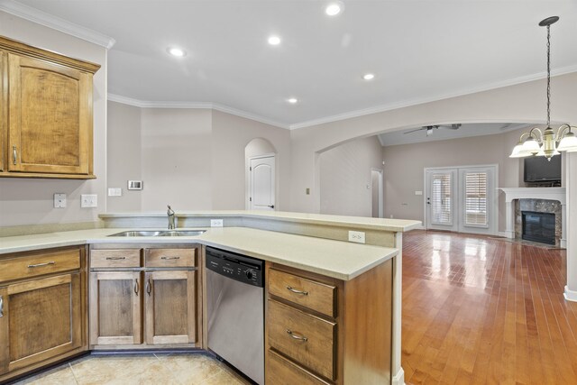 kitchen with stainless steel dishwasher, a sink, a peninsula, open floor plan, and ornamental molding