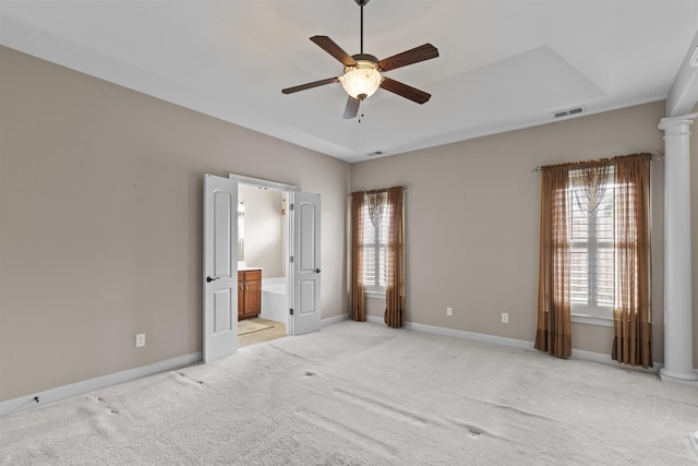 unfurnished bedroom with light carpet, decorative columns, and baseboards