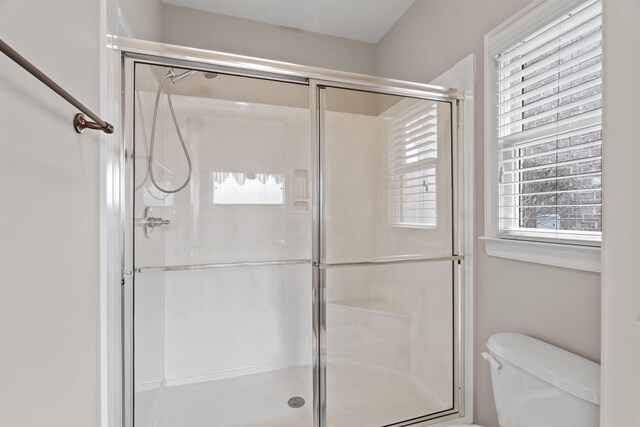 full bathroom with a stall shower and toilet