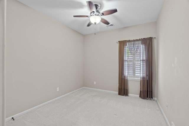 empty room with a ceiling fan, light carpet, and baseboards
