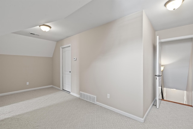 bonus room featuring light colored carpet and baseboards