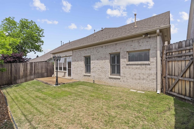 rear view of house with brick siding, roof with shingles, a patio, and a gate