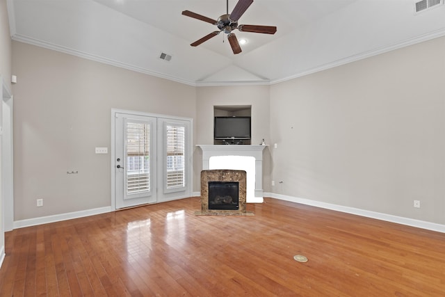unfurnished living room with a fireplace, ceiling fan, wood finished floors, lofted ceiling, and baseboards
