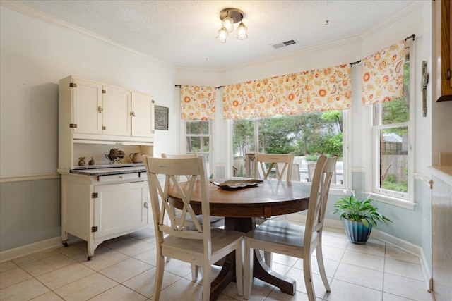 7733 Quick Fox Cv, Memphis, TN 38016 - dining space featuring healthy amount of natural light, ornamental molding, light tile patterned floors, a textured ceiling, and baseboards