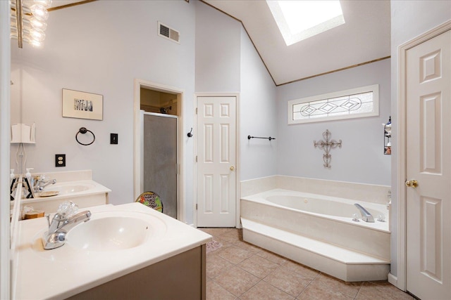 7733 Quick Fox Cv, Memphis, TN 38016 - bathroom with a skylight, a stall shower, tile patterned floors, a bath, and high vaulted ceiling