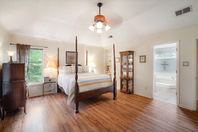 7733 Quick Fox Cv, Memphis, TN 38016 - bedroom featuring wood finished floors, baseboards, vaulted ceiling, and ensuite bath