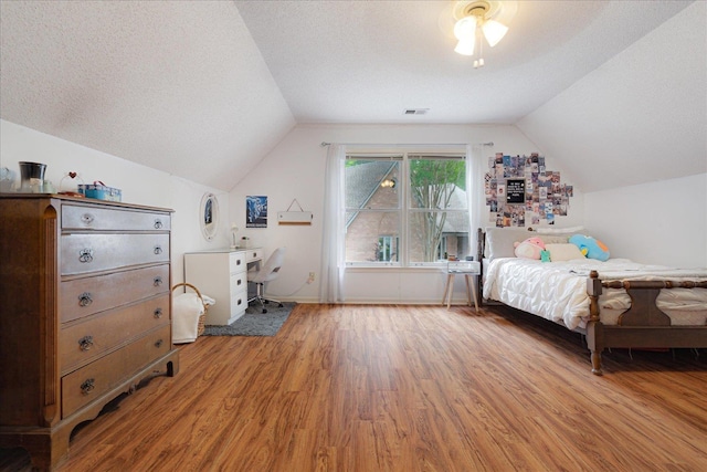 7733 Quick Fox Cv, Memphis, TN 38016 - bedroom with light wood-type flooring, lofted ceiling, a textured ceiling, and baseboards