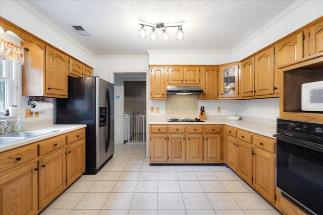 7733 Quick Fox Cv, Memphis, TN 38016 - kitchen with black oven, under cabinet range hood, a sink, light countertops, and stainless steel fridge