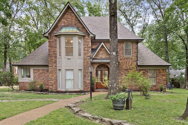 787 Pearson Oaks Dr, Collierville, TN 38017 - tudor-style house with a shingled roof, a front lawn, brick siding, and french doors
