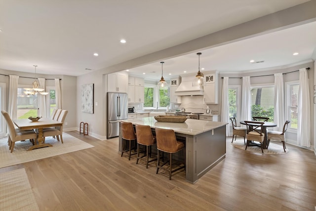 787 Pearson Oaks Dr, Collierville, TN 38017 - kitchen featuring freestanding refrigerator, a large island, custom exhaust hood, white cabinetry, and light stone countertops