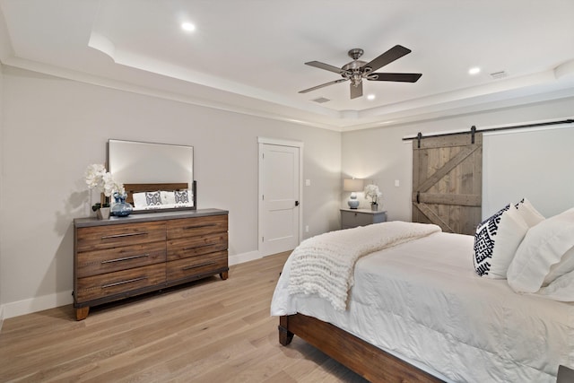 787 Pearson Oaks Dr, Collierville, TN 38017 - bedroom with a tray ceiling, a barn door, light wood finished floors, recessed lighting, and baseboards