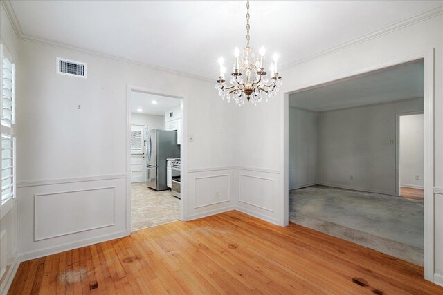 1079 Woodview Dr, Memphis, TN 38117 - unfurnished room with a chandelier, a decorative wall, light wood-style flooring, ornamental molding, and a wainscoted wall