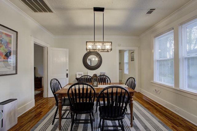 1975 Walker Ave, Memphis, TN 38104 - dining room with dark wood-style flooring, crown molding, and baseboards
