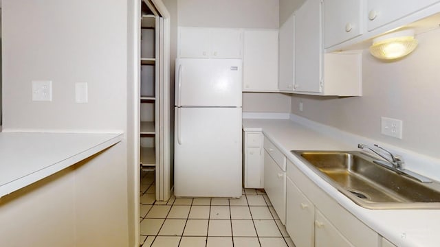 3983 Grahamdale Cir Unit 3983B, Memphis, TN 38122 - kitchen with freestanding refrigerator, a sink, light tile patterned floors, white cabinetry, and light countertops