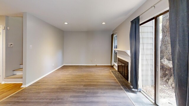 3983 Grahamdale Cir Unit 3983B, Memphis, TN 38122 - unfurnished living room featuring a tiled fireplace, wood finished floors, recessed lighting, baseboards, and stairs