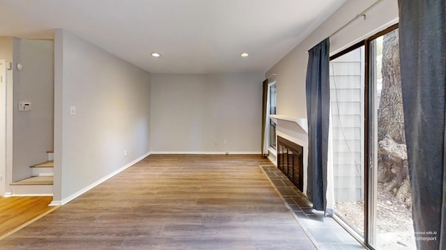 3983 Grahamdale Cir Unit 3983B, Memphis, TN 38122 - unfurnished living room with a tiled fireplace, wood finished floors, recessed lighting, stairway, and baseboards