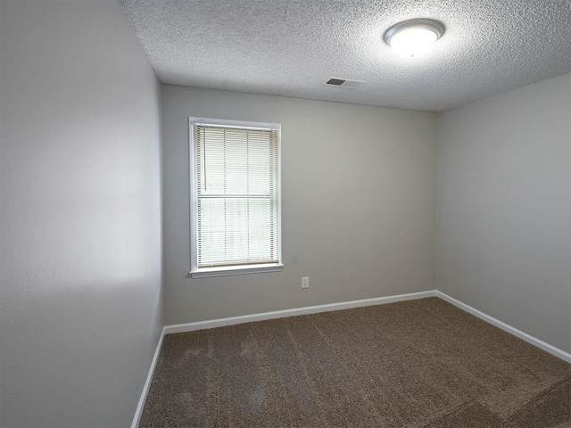 carpeted empty room with a textured ceiling and baseboards